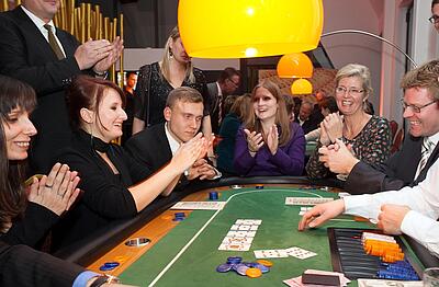 Participants applaud at the poker table during team building.