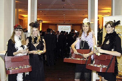 Four hawker girls hand out tokens at the entrance to the event space