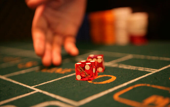 rolling hand with two dice at a craps dice table