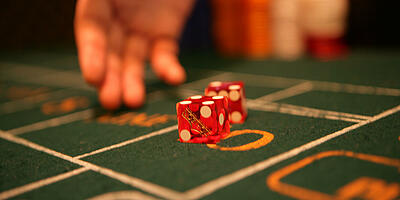 rolling hand with two dice at a craps dice table